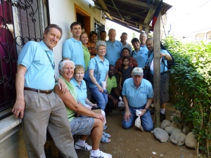 Our Board members and a few staff with Carmen outside her home which she has been able to invest in with a Home Improvement Loan